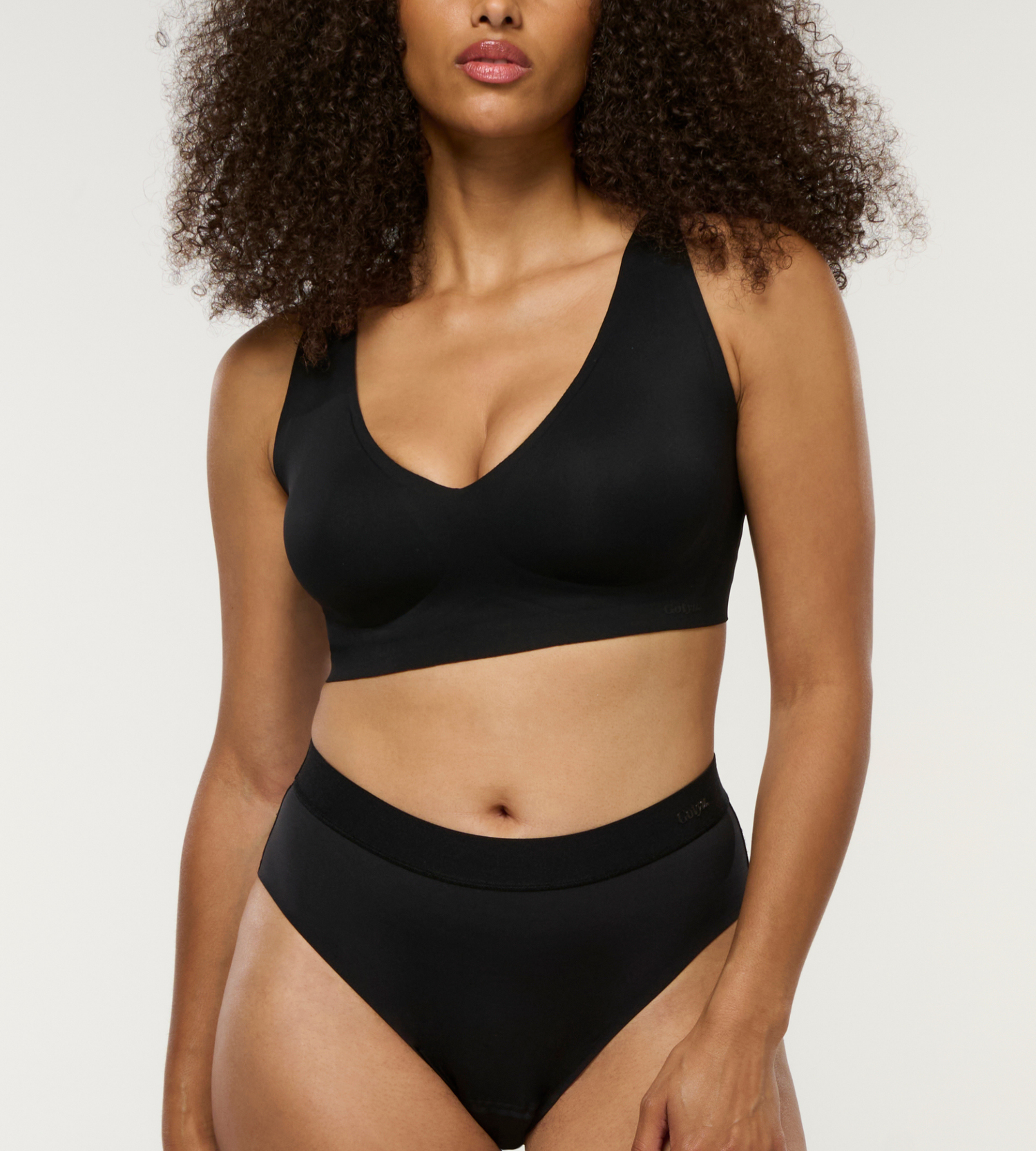 Model trägt bügellosen BH in schwarz, super bequem und mit schönem Dekolte 