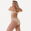Model trägt nahtlosen Menstruationsslip mit praktischen seitlicher Verschlüssen und absolut auslaufsicher in beige 