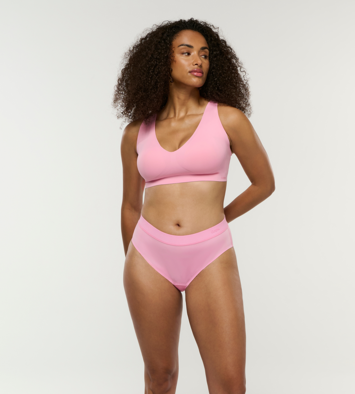 Model trägt super bequemes Set aus auslaufsicherer Menstruationsnunterwäsche und V-Plunge Bralette mit schönem Ausschnitt in pink 

